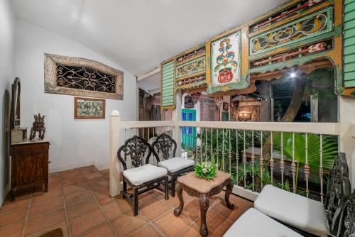 a room with two chairs and a window at Hotel Tugu Blitar in Blitar
