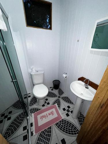 a bathroom with a toilet and a sink at Vista do Lago Jungle Lodge in Cajual