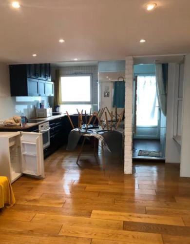 Il comprend une cuisine et un salon avec du parquet. dans l'établissement Studio lumineux avec mezzanine, à Lagord