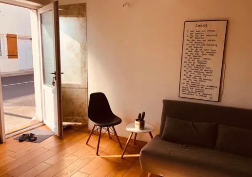 un salon avec un canapé et une chaise dans l'établissement Studio lumineux avec mezzanine, à Lagord