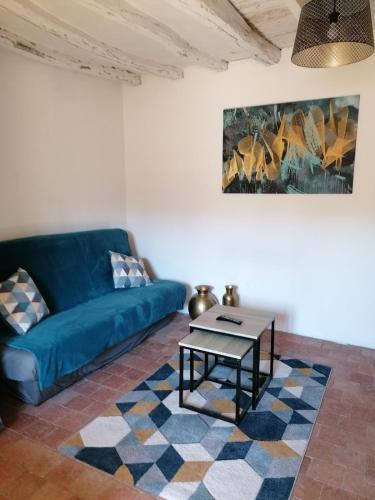 un salon avec un canapé bleu et une table dans l'établissement Home, Saint Léonard des bois, à Saint-Léonard-des-Bois