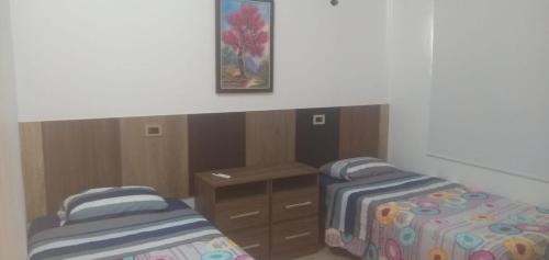 a bedroom with two beds and a desk and a painting at San Vicente - Misiones in San Vicente