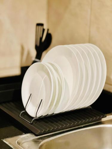 a white plate sitting on a rack next to a sink at Best Place Holiday Home Free Parking in Ajman 