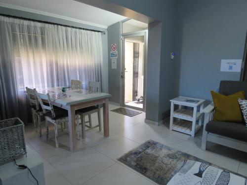 a living room with a table and a couch at Destiny Jeffreys bay in Jeffreys Bay
