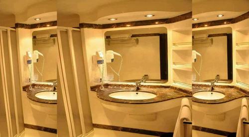a bathroom with three sinks and two mirrors at مركب ريفر River Boat in Cairo