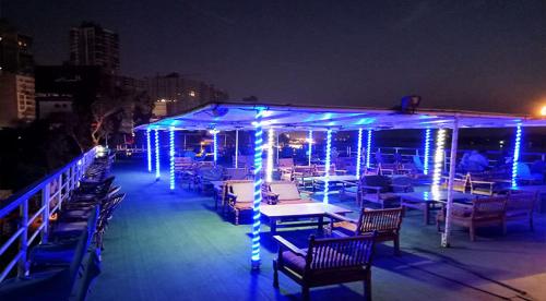 a deck with tables and chairs with blue lights at مركب ريفر River Boat in Cairo
