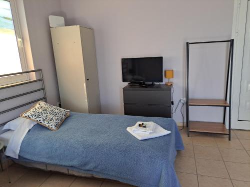 a bedroom with a bed and a tv and a television at Seashell Apartment in Artemida