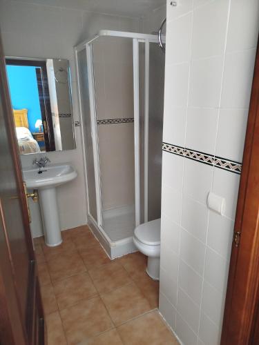 a bathroom with a shower and a toilet and a sink at Hotel Restaurante El CID in Torres de Albarracín