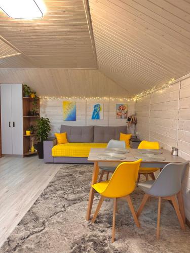 a living room with a table and yellow chairs at Три-О Апартаменти з видом на гори, максимум для 4 гостей, 15 хв від центру in Slavske