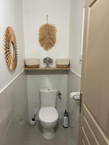 La salle de bains est pourvue de toilettes et d'une étagère avec des paniers. dans l'établissement A l'Ombra Di l'Alivu, à Figari