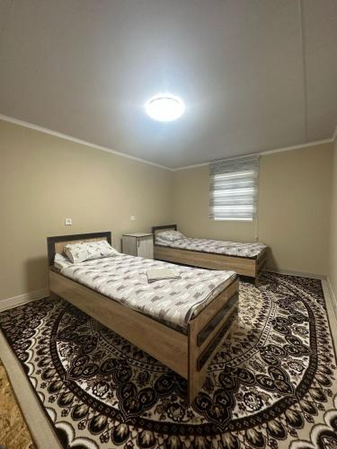 two beds in a room with a rug at Aida guest house in Arkit