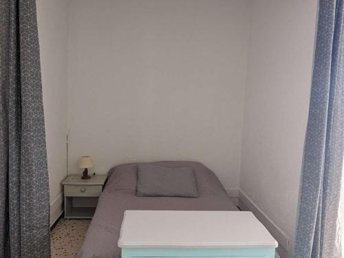 - une petite chambre avec un petit lit et une table dans l'établissement Appartement ensoleillé avec terrasse et parking, à 2 pas de la plage - Marseillan - FR-1-387-169, à Marseillan