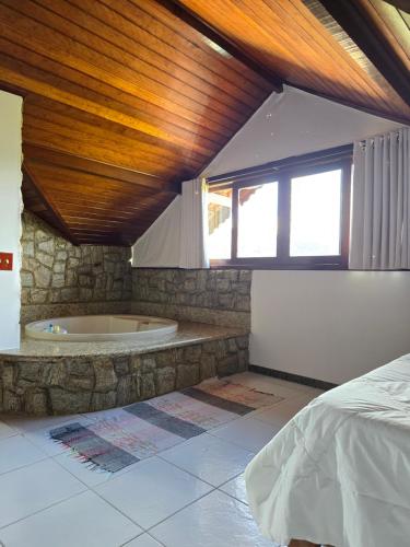 a bedroom with a tub and a bed in a room at Pousada Bela Mauá in Itatiaia