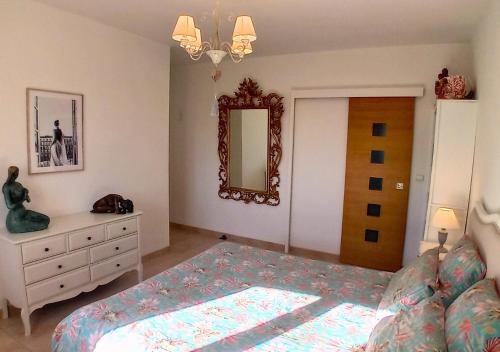 a bedroom with a bed and a dresser and a mirror at La petite maison de Valérie proche château de la Rode, du Domaine de Flore et du Lac Saint Ferréol in Lempaut