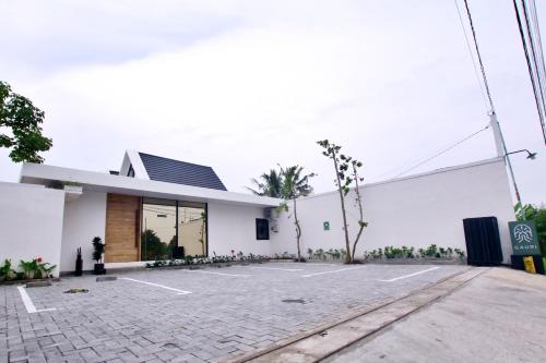a white building with a parking lot at Gauri Vasanta Villa with Private Pool Yogyakarta in Yogyakarta