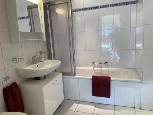a white bathroom with a sink and a toilet at Le Chalet Rosat Apartment 25 in Chateau-d'Oex