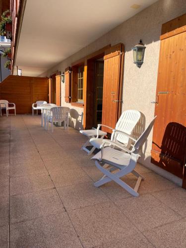 a group of chairs and tables on a patio at Le Chalet Rosat Apartment 25 in Chateau-d'Oex