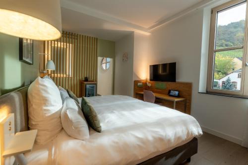 a hotel room with a large bed and a window at DEINHARD's in Bernkastel-Kues