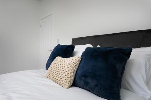 a white bed with blue pillows on it at The Modern Retreat in Leicester