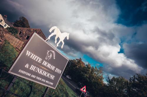 a sign with a white horse on top of it at The White Horse Inn Bunkhouse in Threlkeld