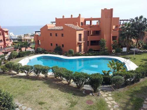 a large blue swimming pool in front of a building at Jardines de Nueva Galera en Estepona in Estepona