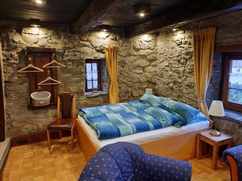 a bedroom with a bed and a stone wall at Alter Spieker Sundern-Endorf in Endorf