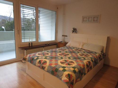 a bedroom with a bed and a large window at Ferienwohnung M Löffler in Lörrach