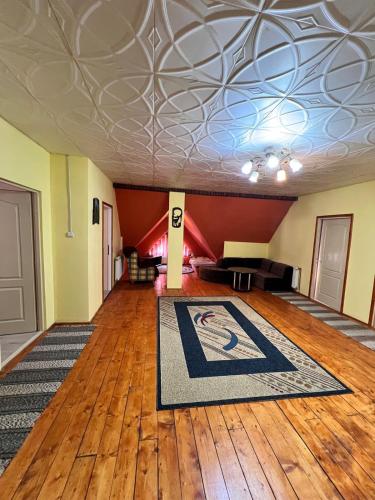 a large room with a rug on a wooden floor at Küsmödi Vendégház in Jolotca