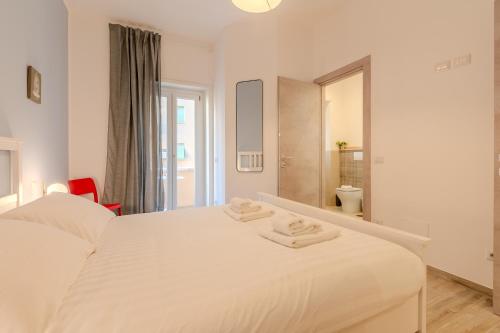 a bedroom with a white bed with two towels on it at Maria Magdalena Apartment Saint Peter's in Rome