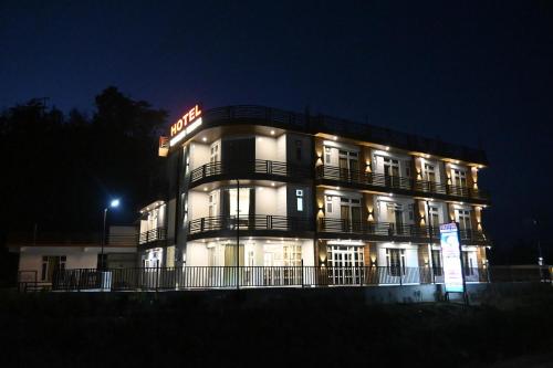 a lit up building at night with a hotel at Hotel Rewalsar Heights in Mandi