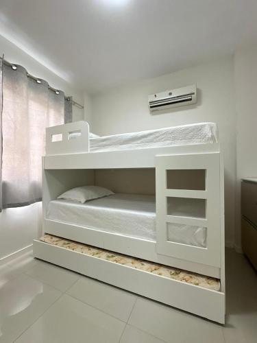 a white bunk bed in a white room at Apartamento Centro de bombas in Bombinhas