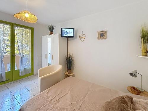 a bedroom with a bed and a tv on the wall at Dans une station thermale, Studio dans résidence avec ascenseur in Amélie-les-Bains-Palalda