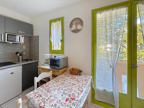 a kitchen with a table and a small kitchen with a table and a window at Dans une station thermale, Studio dans résidence avec ascenseur in Amélie-les-Bains-Palalda