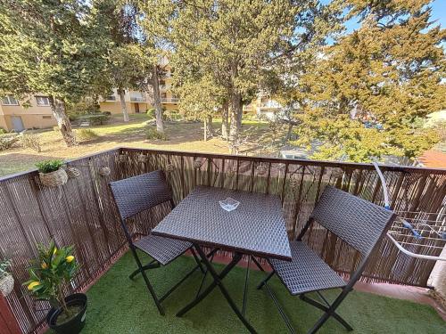 une table de pique-nique et deux chaises sur un balcon dans l'établissement Dans une station thermale, Studio dans résidence avec ascenseur, à Amélie-les-Bains-Palalda