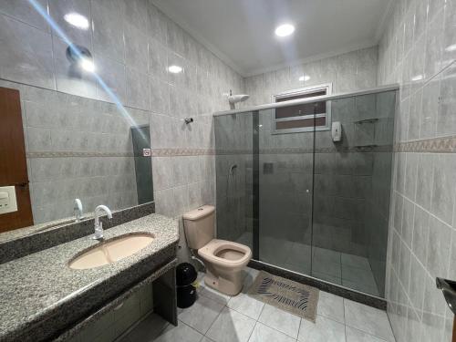 a bathroom with a toilet and a sink and a shower at Angel Hospedagem Itapuã in Vila Velha