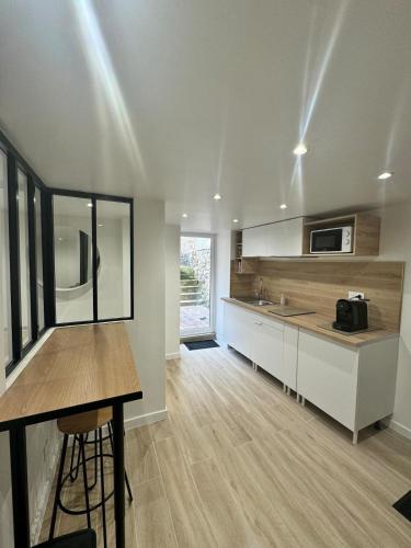 une cuisine avec des armoires blanches et un comptoir dans l'établissement Coconing, à Reims