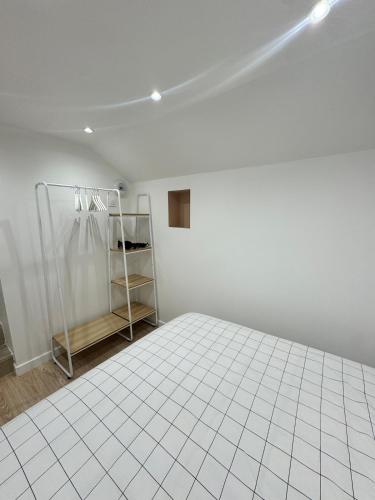 une pièce blanche avec un sol carrelé blanc dans l'établissement Coconing, à Reims