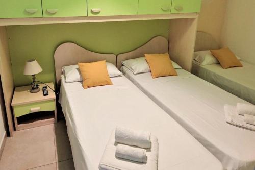 zwei Einzelbetten in einem Zimmer mit grünen Wänden in der Unterkunft Appartamento panoramico per 4 sul lungomare di Castellabate in Santa Maria di Castellabate