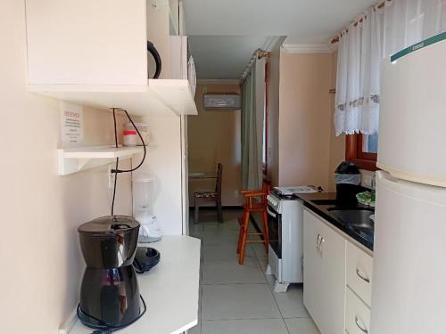 a kitchen with white cabinets and a blender at Novo Aconchego in Gramado