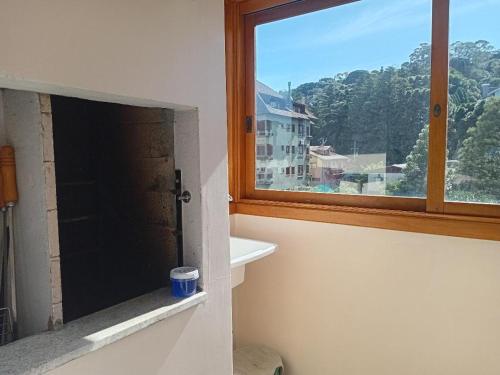 a window in a bathroom with a view of a building at Novo Aconchego in Gramado