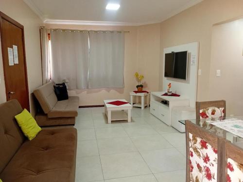 a living room with a couch and a tv at Novo Aconchego in Gramado