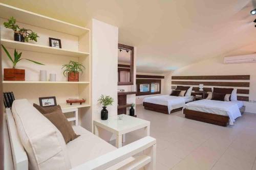 a living room with two beds and a couch at Villa Kandia in Ayia Evfimia