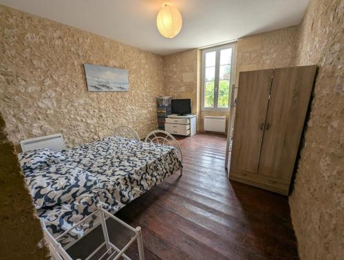 a bedroom with a bed and a cabinet and a television at Maison de campagne 8 couchages avec piscine et lacs in Sainte-Radegonde