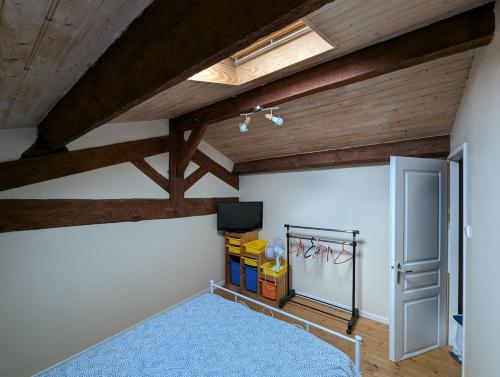 a attic room with wooden ceilings and a blue rug at Maison de campagne 8 couchages avec piscine et lacs in Sainte-Radegonde