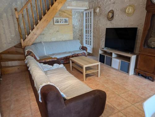 a living room with a couch and a television at Maison de campagne 8 couchages avec piscine et lacs in Sainte-Radegonde
