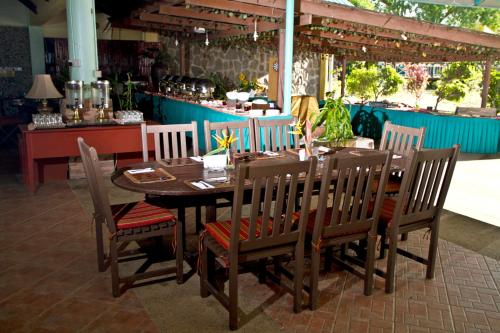 a wooden dining table and chairs in a restaurant at Beringgis Beach Resort & Spa in Papar