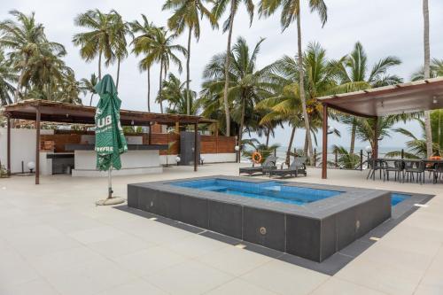 a pool at the resort with palm trees in the background at Tills Beach Resort in Fetta