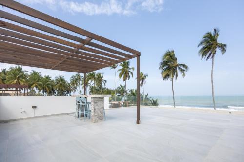 an outdoor patio with palm trees and the ocean at Tills Beach Resort in Fetta