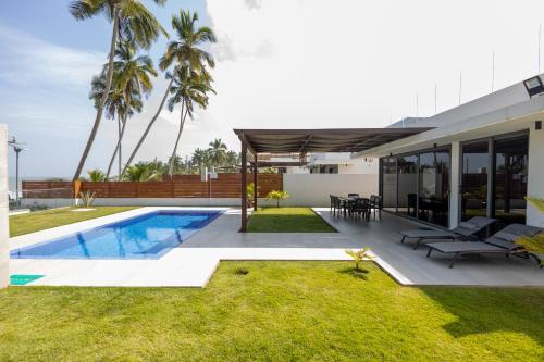 a backyard with a swimming pool and a house at Tills Beach Resort in Fetta