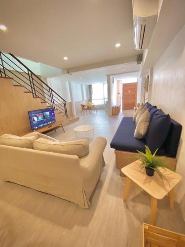 a living room with a couch and a tv at Vann House Hua Hin in Hua Hin